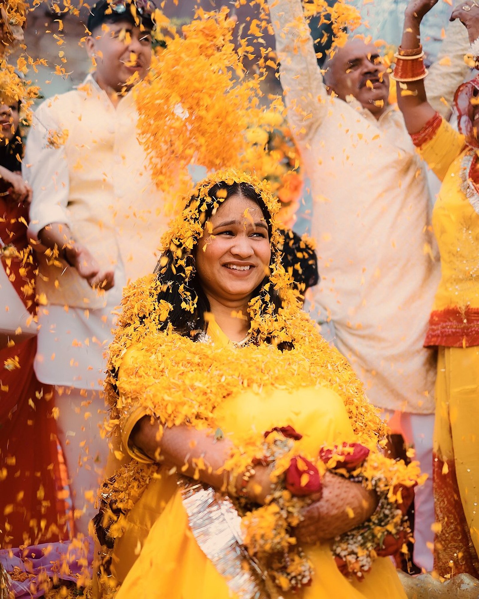 Bride showered with marigold petals at haldi ceremony
