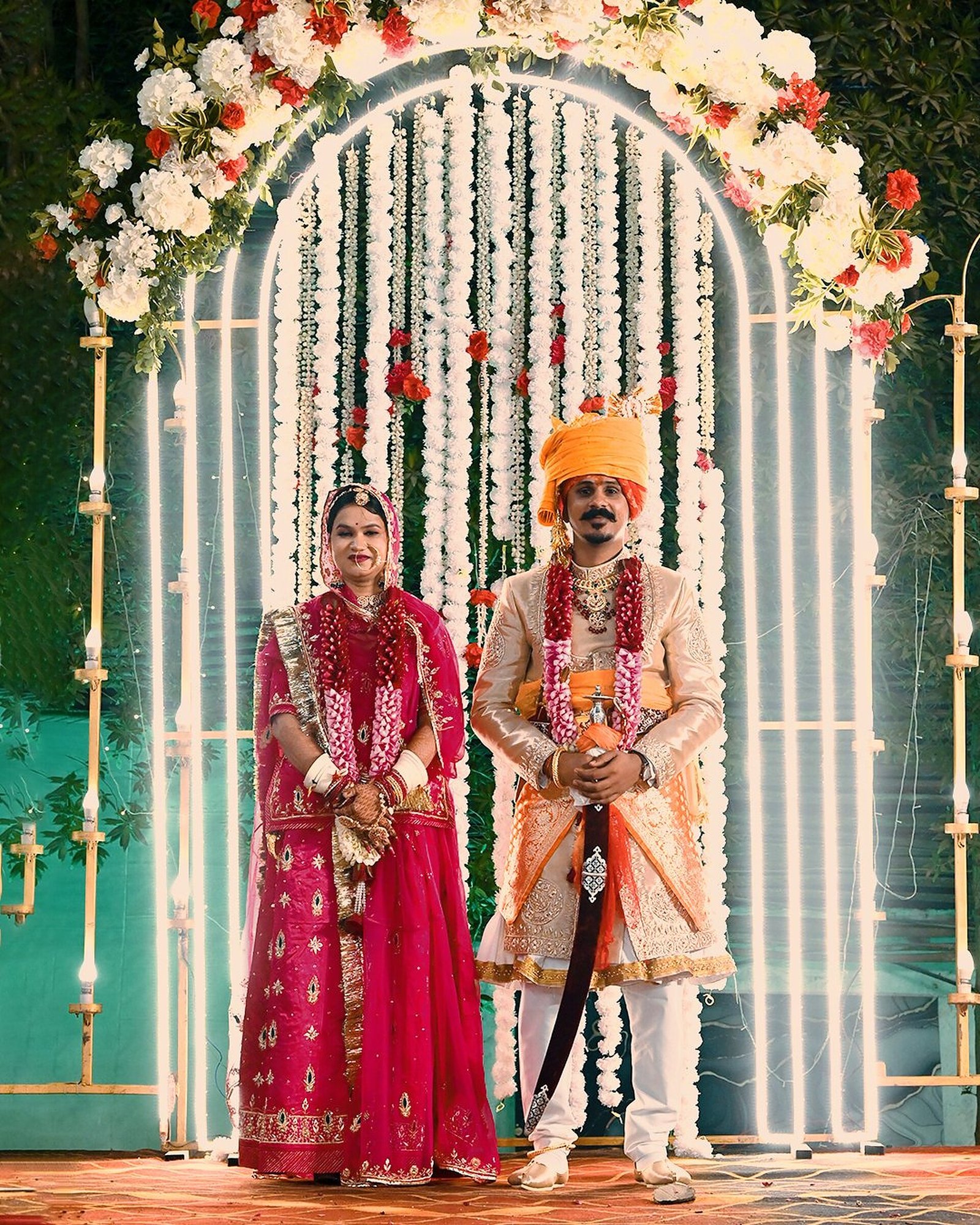 Couple portrait under floral wedding arch